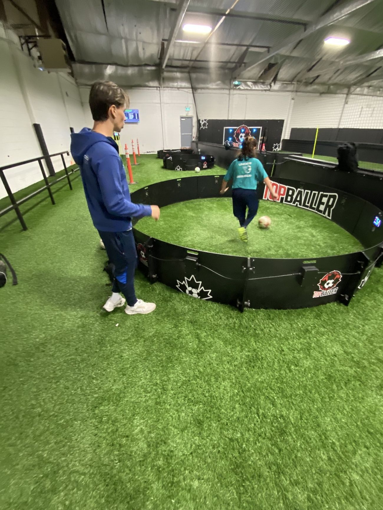 Joshua Pulla coaching a young player through a training drill